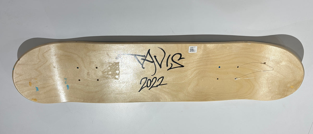 A wooden skateboard with a signature on it