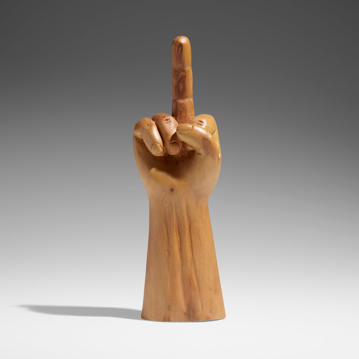 a sculpture of a gold hand with the middle finger pointed