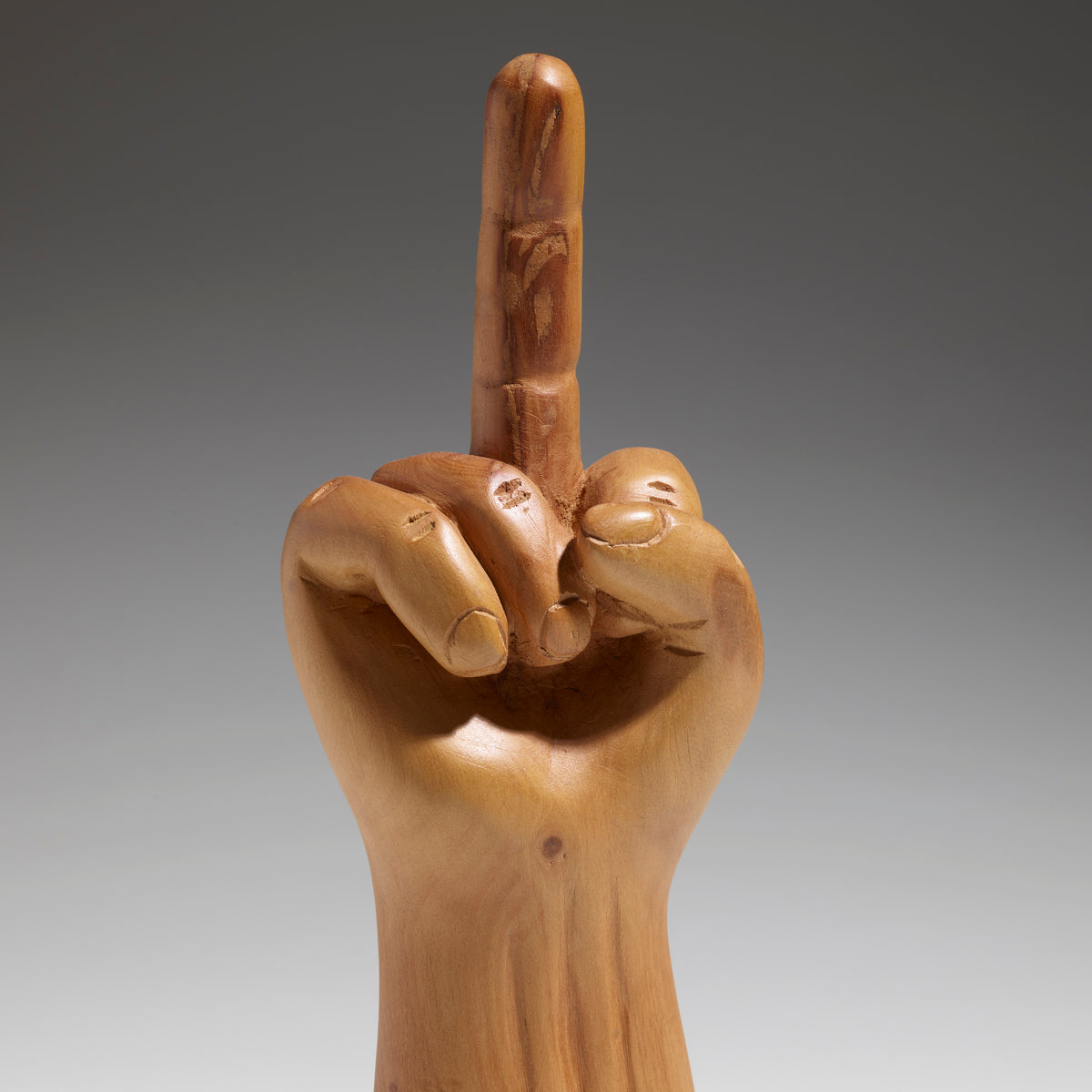 a sculpture of a gold hand with the middle finger pointed